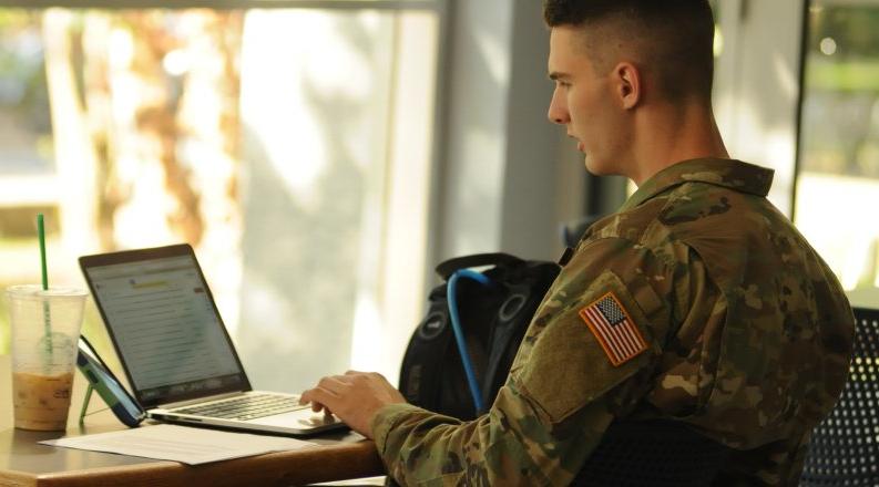 身着军装的学生在笔记本电脑上工作. 